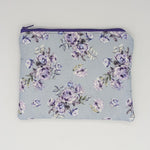 Rose patterned pouch with purple zipper on a light blue background